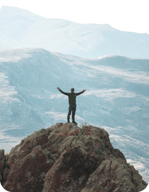 Man on top of the mountain with open arms